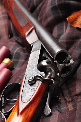 Hunting double barrel vintage shotgun, cartridge case on the on the hunters jacket in cell, close-up.Copy space.Concept hunting.Englsih hunter concept.Autumn