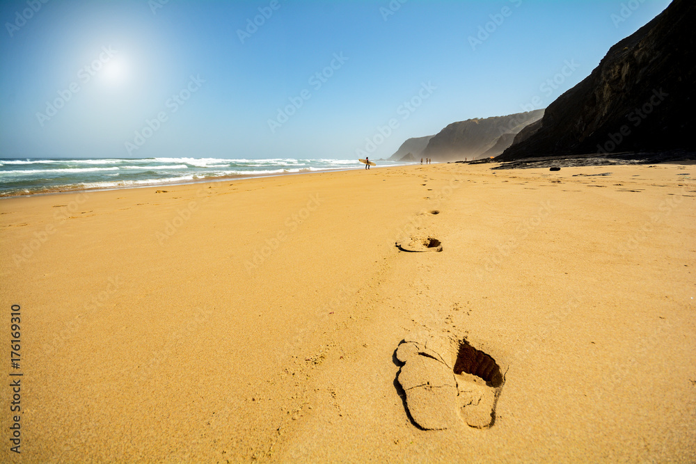 Fototapeta premium Footsteps in the sand at beach Praia do Vale dos Homens near Aljezur, Algarve Portugal