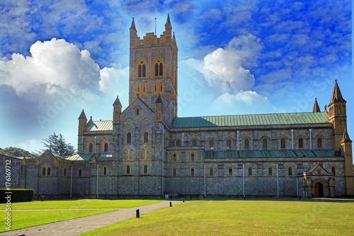 Church Cathedral against a blue cloudy sky and a lush green grass freground photo