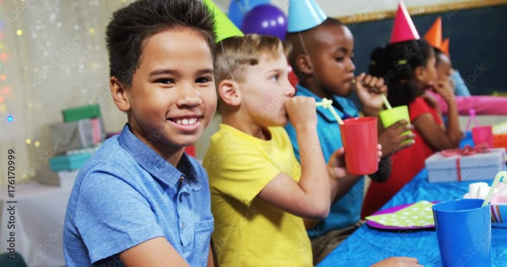 Portrait of boy sitting with friends during birthday party 