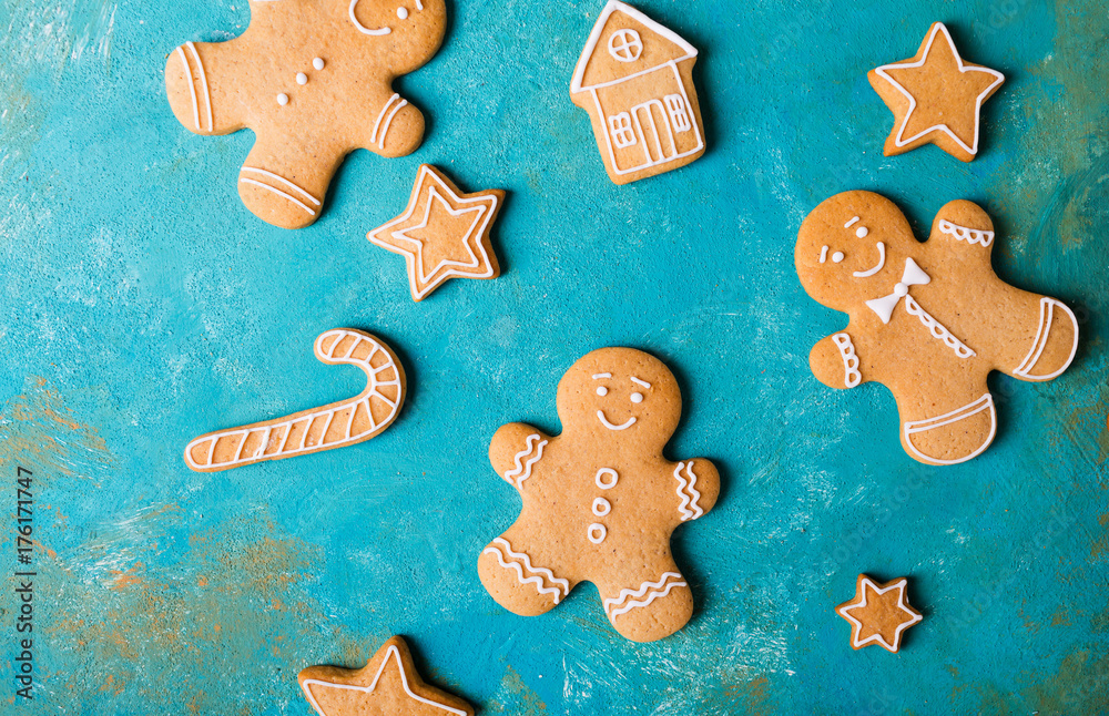 Ginger men with colored glaze on a turquoise background .. Gingerbread. Christmas cookies. Ginger man in a colored sweater. Ginger men with colored glaze on a turquoise background .. Gingerbread. Christmas cookies. Ginger man in a colored sweater.