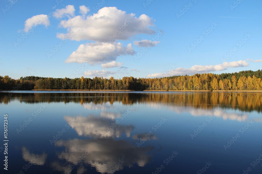 Lake in a delightful autumn forest at sunny day. Autumn trees with reflection. Russia. Lake in a delightful autumn forest at sunny day. Autumn trees with reflection. Russia.