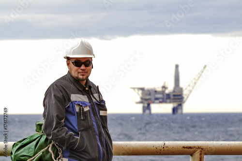 Oilman shift workers on the deck of the ship on the background o