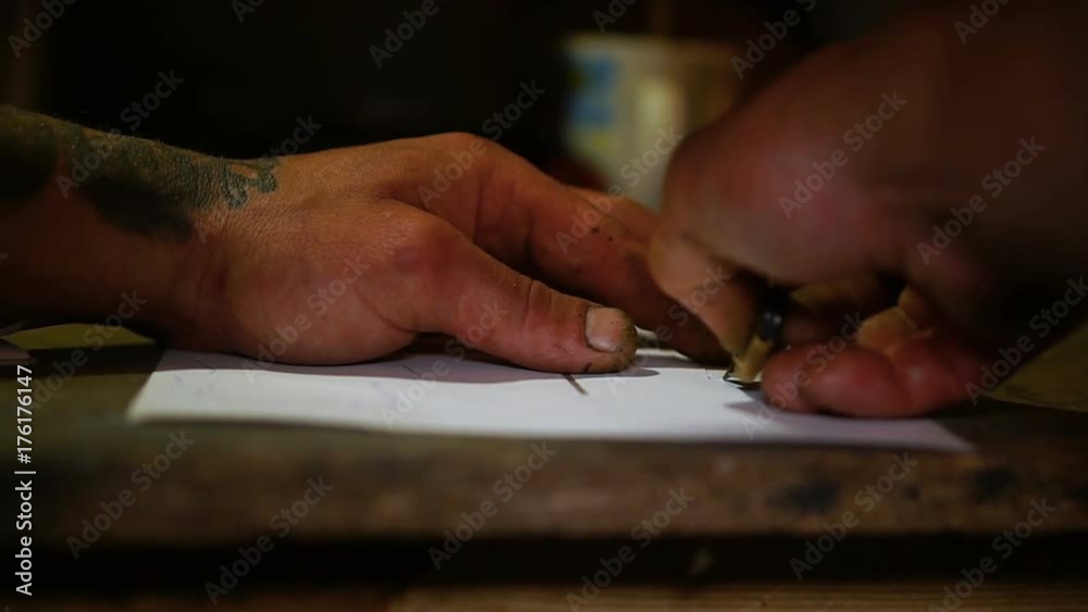 Man cuts out a template for drawing Man cuts out a template for drawing