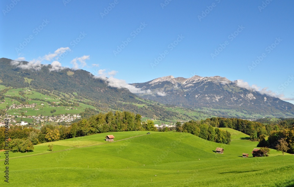 Blick über grüne Wiesen und Wälder auf die Gemeinden Alpnach und Alpnachstad und den Berg Pilatus im Hintergrund - Schweiz