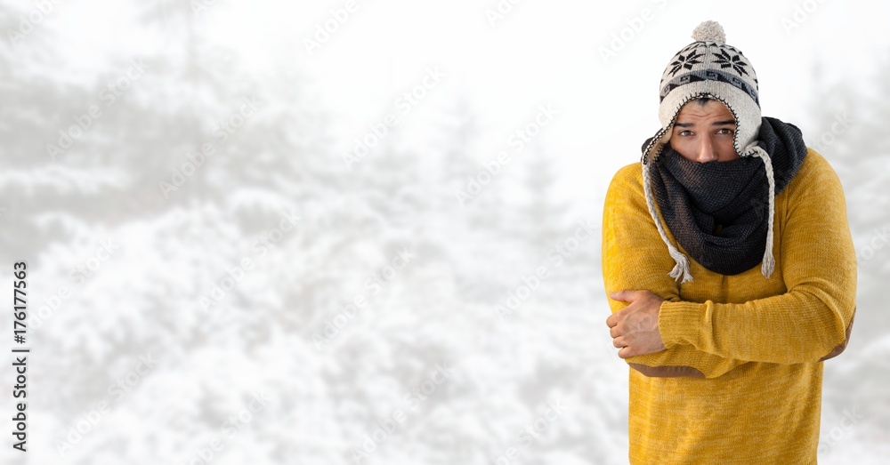 Man keeping warm with hat and scarf in bright snow forest