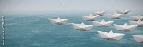 Composite image of paper boats arranged on white background