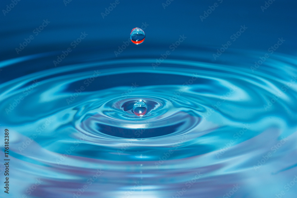 Water drop falling into water Water drop falling into water