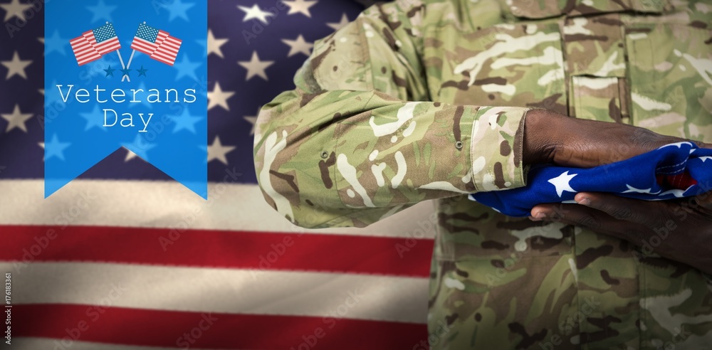 Fototapeta premium Composite image of mid section of soldier holding american flag