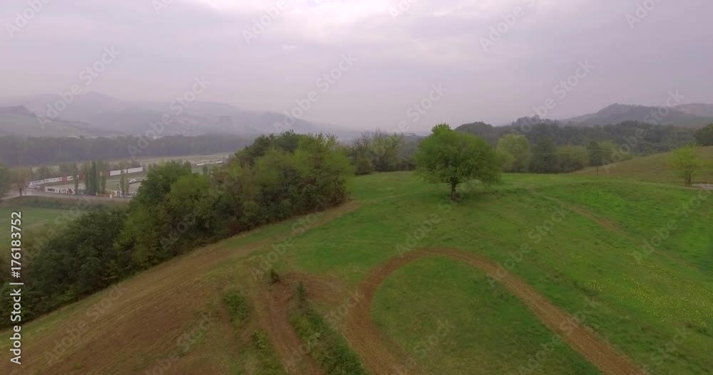Stunning aerial shot over lush green fields and meadows in the Italian countryside at sunset on a cloudy bright autumn day. Environment,agriculture and beauty in nature concept. Stunning aerial shot over lush green fields and meadows in the Italian countryside at sunset on a cloudy bright autumn day. Environment,agriculture and beauty in nature concept.