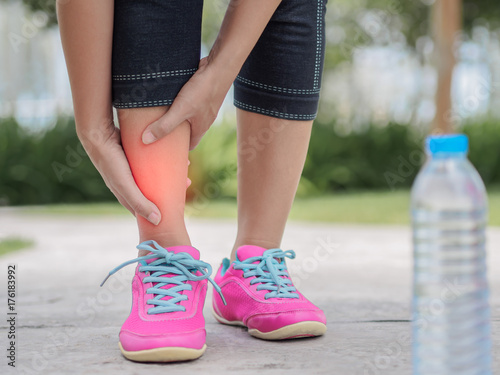 Woman suffering from an ankle injury while exercising.  Running sport injury concept.