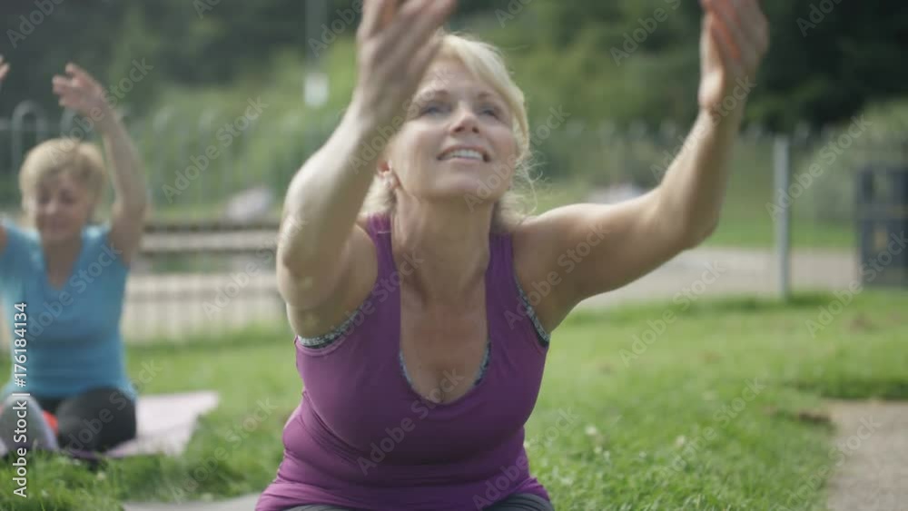 Happy mature female friends doing yoga together in the park Happy mature female friends doing yoga together in the park