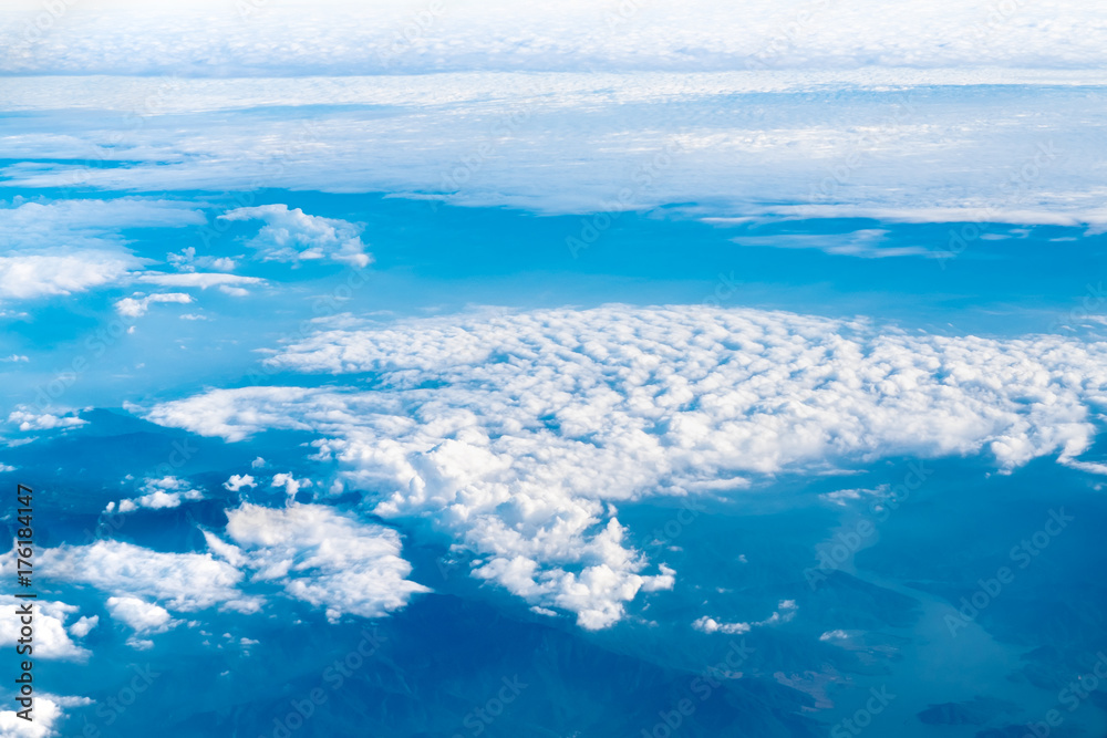 Aerial view of airplane window looking down to cloudy and mountain land ,Nature background