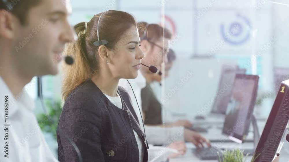  Portrait smiling customer service operator taking calls in busy call center.