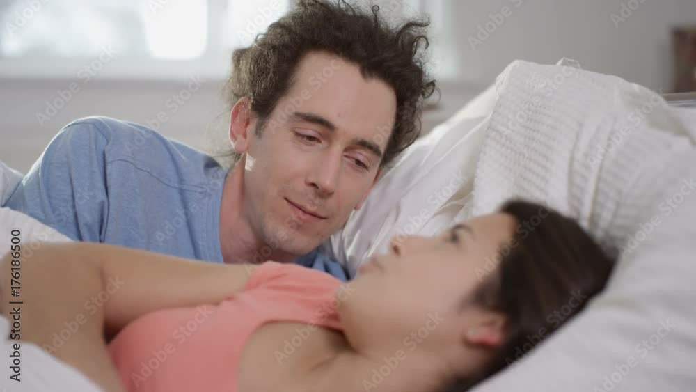 Man trying to instigate affections with his partner in bed but has no success Man trying to instigate affections with his partner in bed but has no success