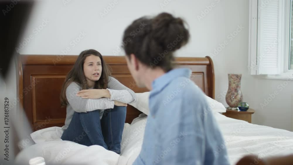 Couple with relationship problems having emotional conversation in bedroom Couple with relationship problems having emotional conversation in bedroom