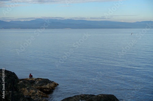  Einzelne Frau im Hintergrund betrachtet szenische Aussicht auf Meer und Inseln.