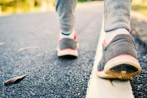 Feet of girl walking in the road , concept exercise,color of vintage tone and soft focus