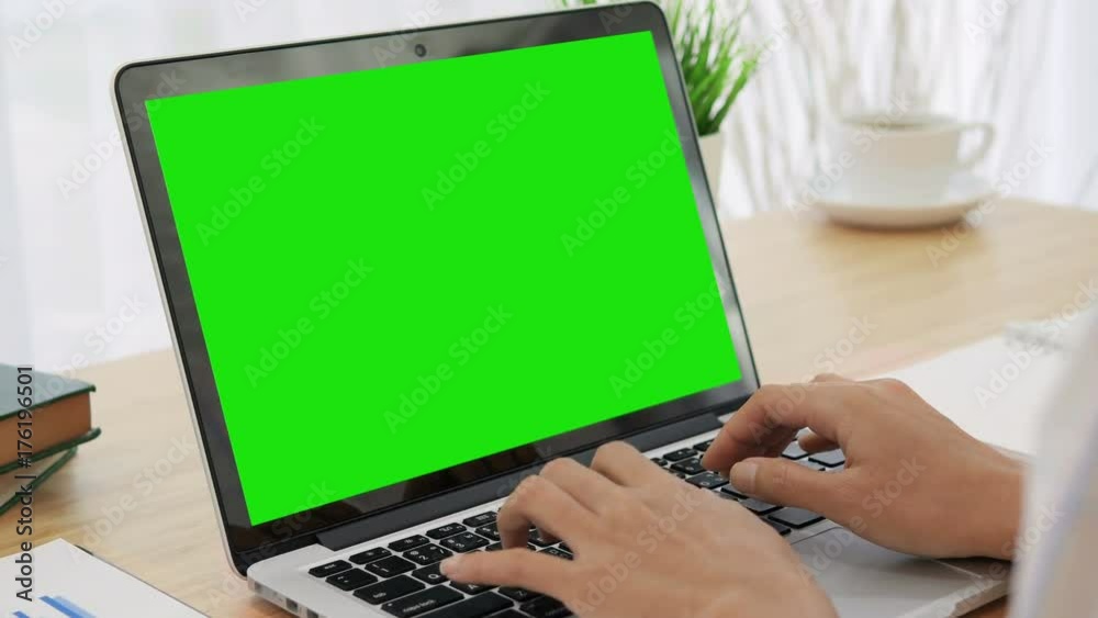 4K : Woman hand typing on a laptop computer with a key green screen.