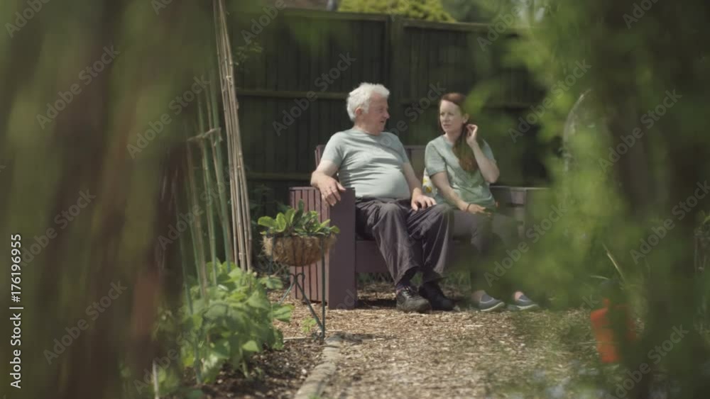 Volunteers chatting & enjoying a peaceful moment in community garden Volunteers chatting & enjoying a peaceful moment in community garden