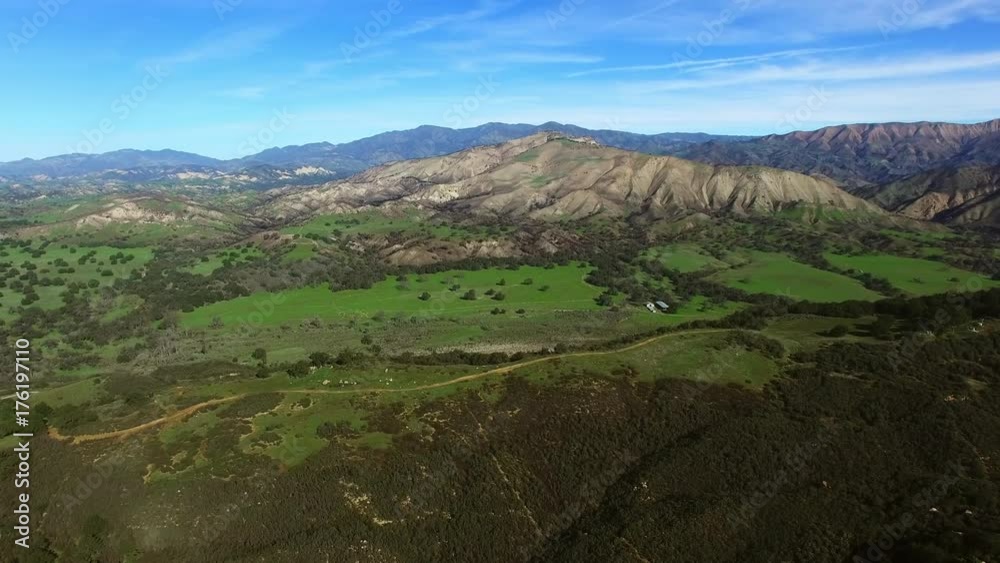 Aerial shot of green field and mountains Aerial shot of green field and mountains