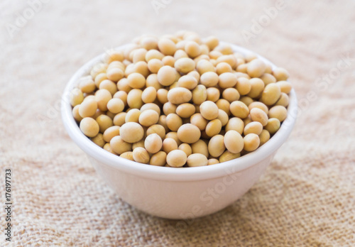 Closeup soy beans on white bowl with sackcloth background , healthy food concept