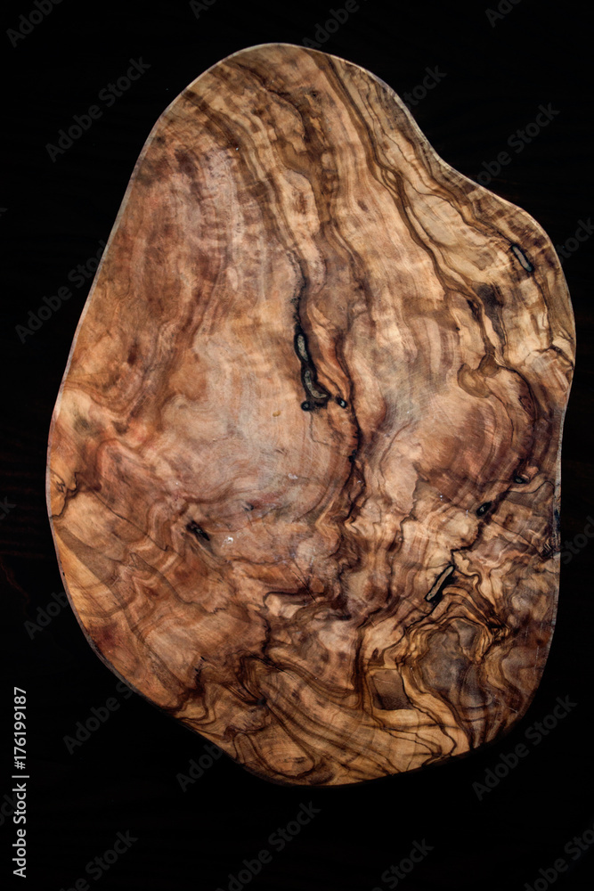 Olive wood brown textured board close up on black background. Vintage wooden background. Olive wood brown textured board close up on black background. Vintage wooden background.