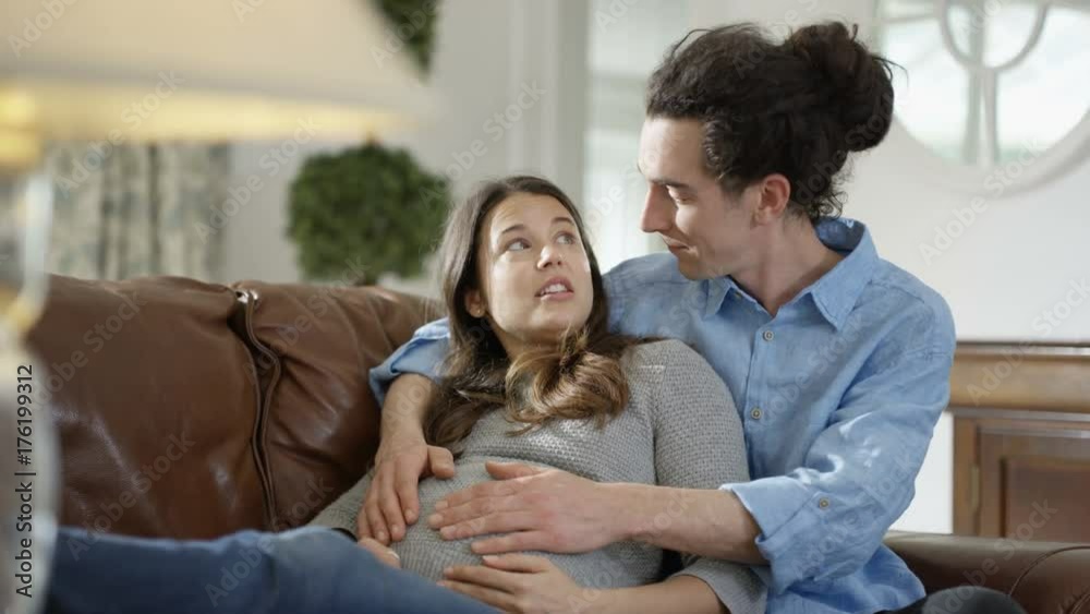 Cheerful couple expecting a baby relaxing together at home Cheerful couple expecting a baby relaxing together at home