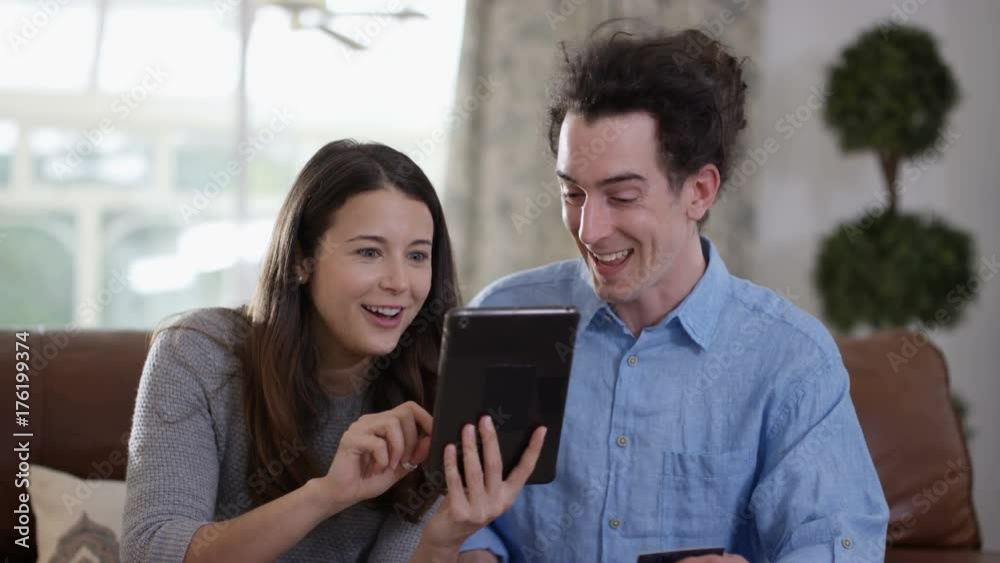 Cheerful couple with tablet & credit card shopping online at home Cheerful couple with tablet & credit card shopping online at home