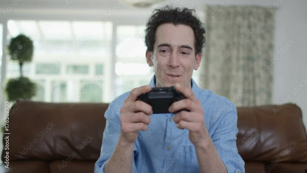 Competitive man playing video games at home, as seen from screen's pov Competitive man playing video games at home, as seen from screen's pov