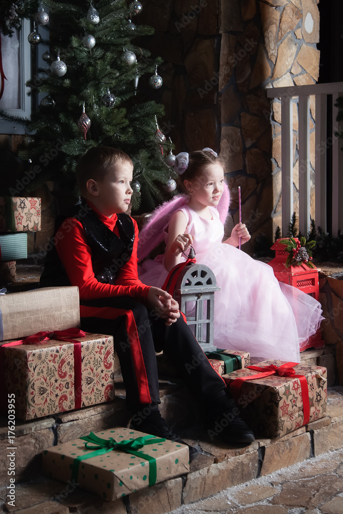 Obraz premium Boy and girl are sitting on the porch with gifts