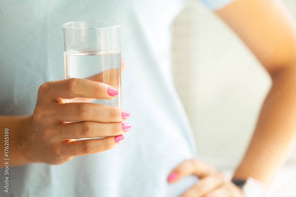 Woman holding a glass of water, close-up Woman holding a glass of water, close-up