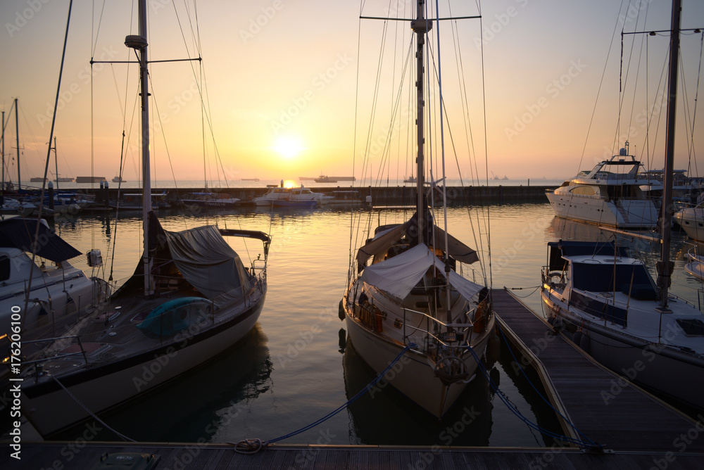Silhouette view of boats at dock with sunrise background in the morning