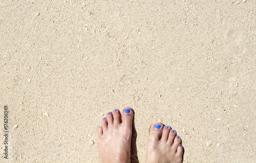 Woman feet on white sand beach. Relaxed barefoot woman by sea.