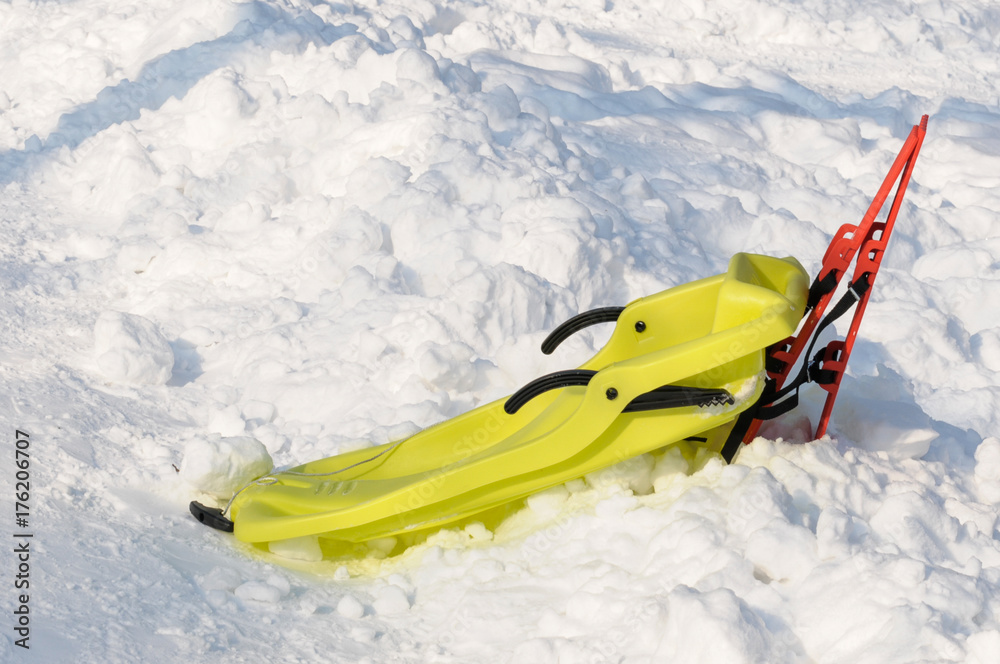 Red and yellow sleighs in the snow, city park Red and yellow sleighs in the snow, city park