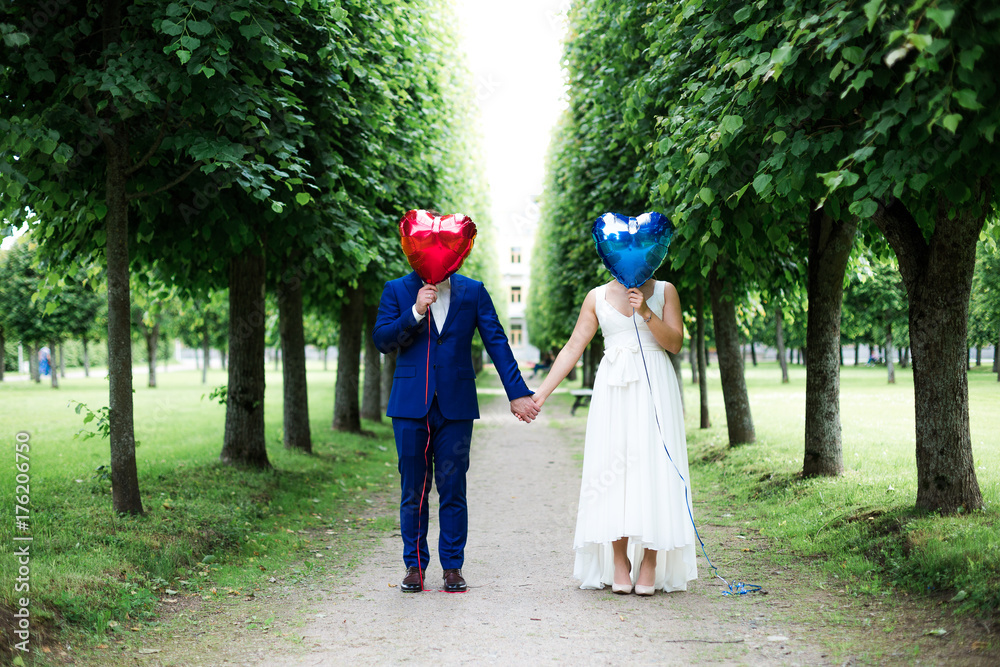 groom and bride with balloons on sidewalk