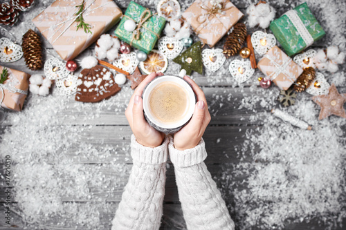 Hands holding a cozy mug with sweet holiday food. Winter and Christmas time concept.
