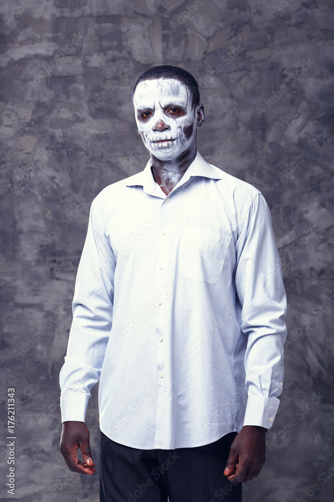 Portrait of an african businessman in the image of a skeleton or zombie. Festival, carnival, party, Halloween male african zombies. African people. Voodoo people. Business man in the form of a zombie. Portrait of an african businessman in the image of a skeleton or zombie. Festival, carnival, party, Halloween male african zombies. African people. Voodoo people. Business man in the form of a zombie.