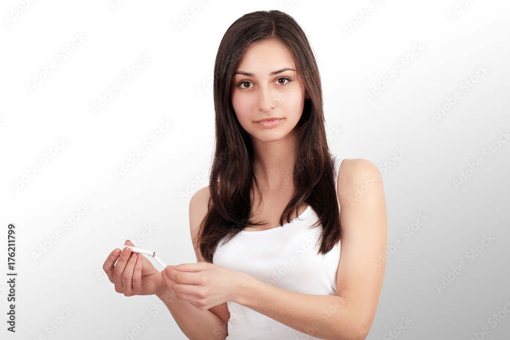 Stop smoking concept. Young woman cut cigarettes with scissors happy smiling. focus on hand, scissors and cigarettes Stop smoking concept. Young woman cut cigarettes with scissors happy smiling. focus on hand, scissors and cigarettes