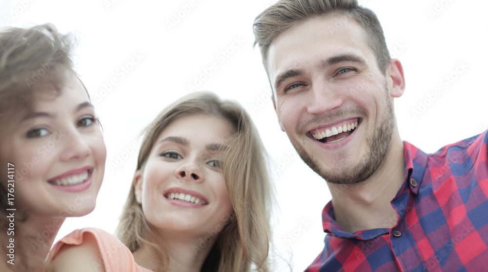 closeup of three young people smiling on white background closeup of three young people smiling on white background