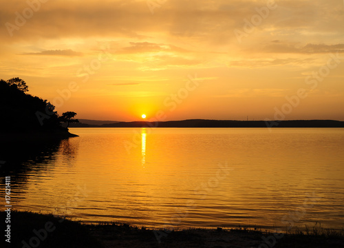 Sunset scene on the lake with good tree silhouette