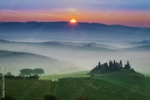 Stunning foggy green fields at sunset in Tuscany
