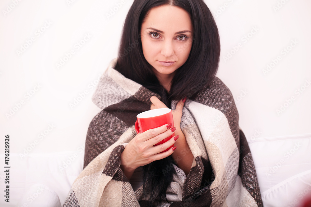 Attractive young woman sitting with a cup of coffee in a white bed Attractive young woman sitting with a cup of coffee in a white bed