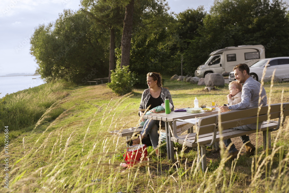 Parents with sons (18-23, 0-1 months) sitting by picnic table Parents with sons (18-23, 0-1 months) sitting by picnic table