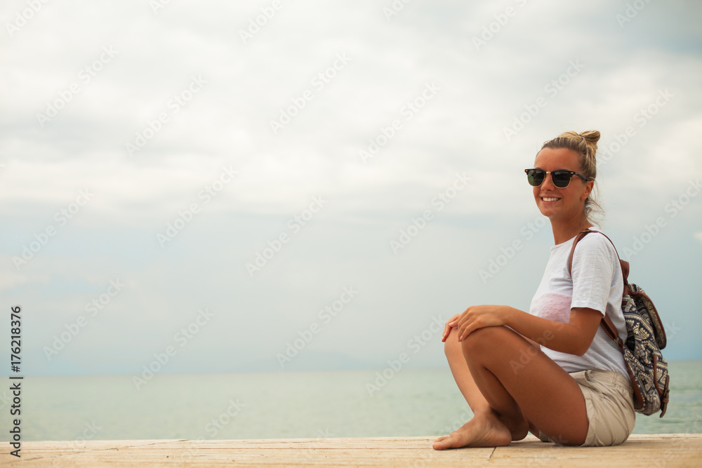 Happy woman sitting on seacoast