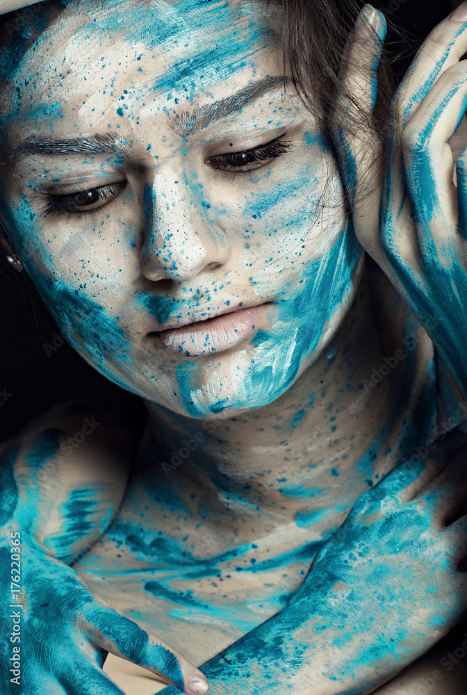 Beautiful model with creative makeup art. Caucasian girl with painted face in blue white flowers