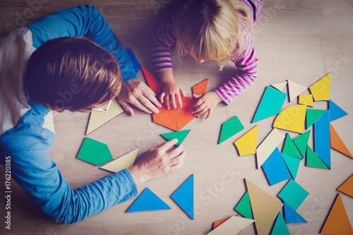 teacher and child playing with geometric shapes