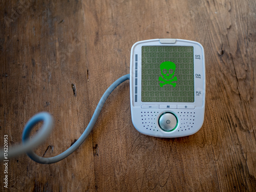 Medical device is hacked or infected by virus. Modern health care concept. Malware on blood pressure display.