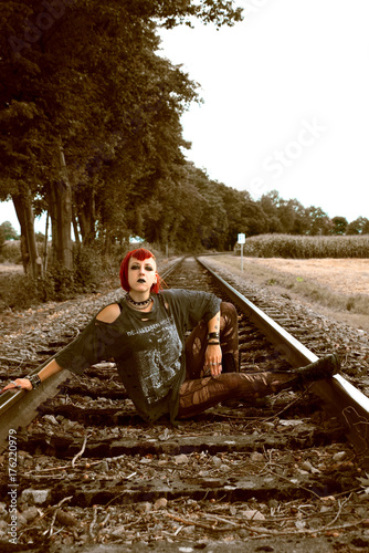 Fototapeta Naklejka Na Ścianę i Meble -  Junge Punk-Frau sitzt auf Schienen 