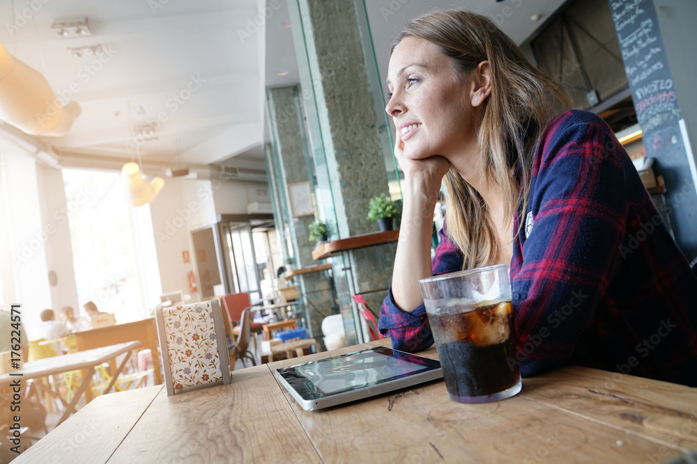 Cheerful woman in coffee shop using digital tablet Cheerful woman in coffee shop using digital tablet